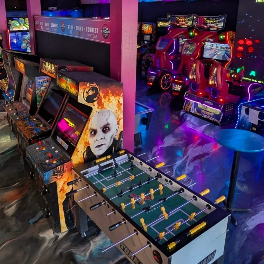 A row of classic fighting-game cabinets beside a foosball table